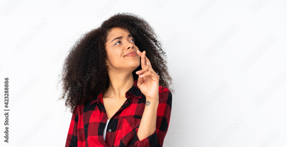 Young african american woman over isolated background with fingers crossing and wishing the best Young african american woman over isolated background with fingers crossing and wishing the best
