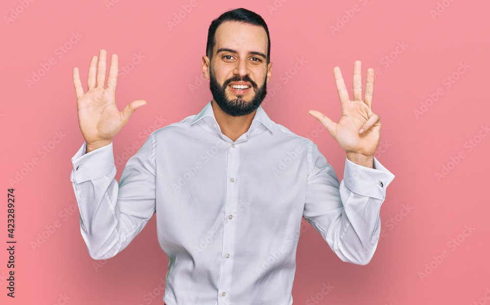 Young man with beard wearing business shirt showing and pointing up with fingers number nine while smiling confident and happy. Young man with beard wearing business shirt showing and pointing up with fingers number nine while smiling confident and happy.
