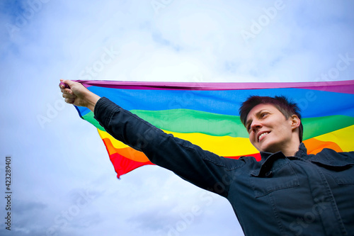 smiling woman holding lgbt rainbow flag