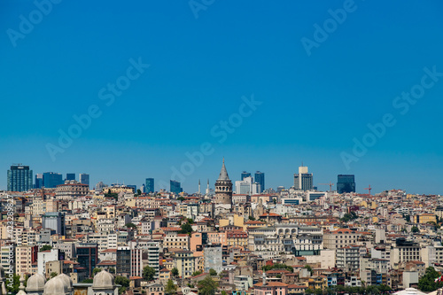 Beautiful panoramic view of cityscape of Istanbul with a lot of colorful buildings and rooftops including Galata Tower with clear blue sky. Summer urban background with copy space area for your text