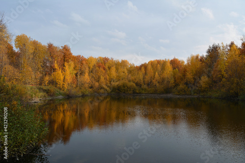 Beautiful autumn landscape with lake and colorful trees on its bank.