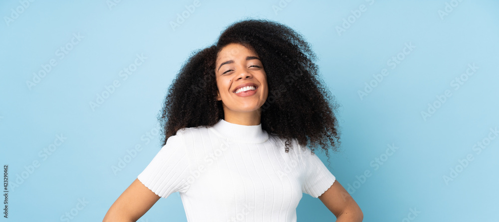 Young african american woman over isolated background posing with arms at hip and smiling Young african american woman over isolated background posing with arms at hip and smiling