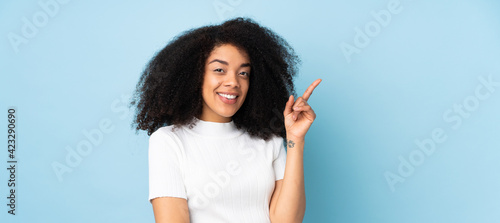 Young african american woman over isolated background pointing up a great idea