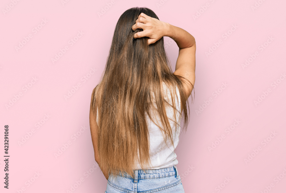 Young hispanic woman wearing casual clothes backwards thinking about doubt with hand on head Young hispanic woman wearing casual clothes backwards thinking about doubt with hand on head