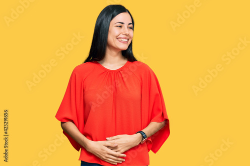 Beautiful young woman wearing casual clothes looking away to side with smile on face, natural expression. laughing confident. © Krakenimages.com