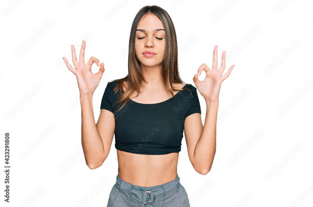 Young brunette woman wearing casual clothes relax and smiling with eyes closed doing meditation gesture with fingers. yoga concept.