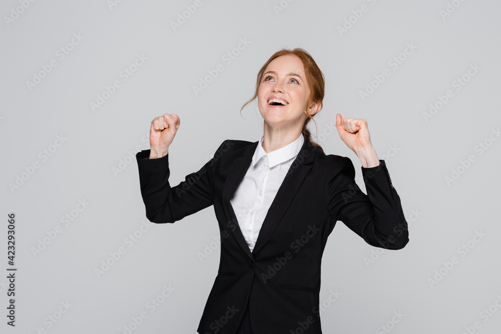 Excited manager showing yes gesture and looking up isolated on grey Excited manager showing yes gesture and looking up isolated on grey