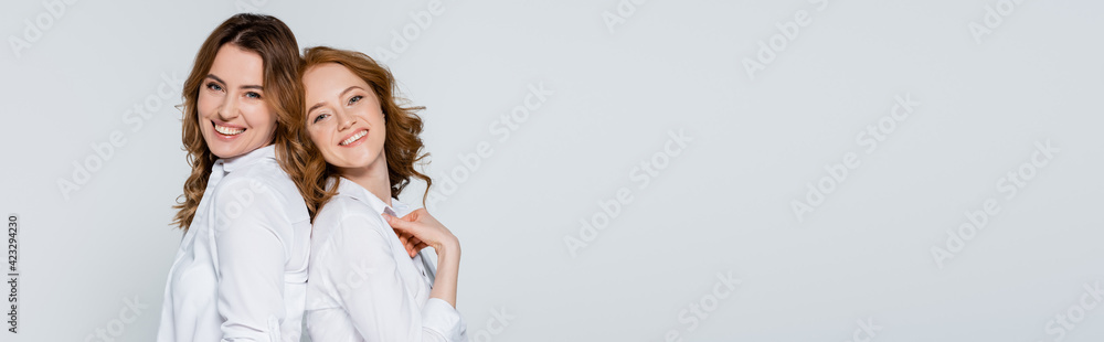 Adult friends standing back to back isolated on grey, banner Adult friends standing back to back isolated on grey, banner
