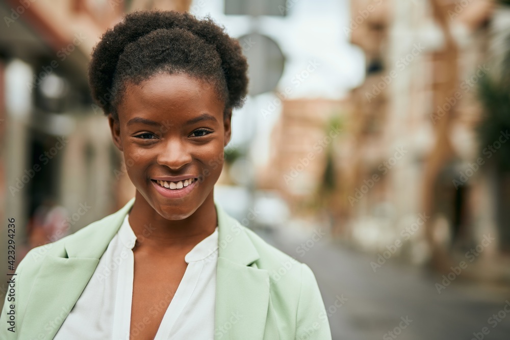 Fototapeta premium Young african american businesswoman smiling happy standing at the city