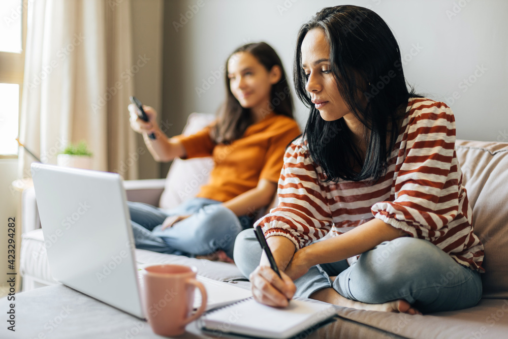 Single mother working from home with preteen daughter around Single mother working from home with preteen daughter around