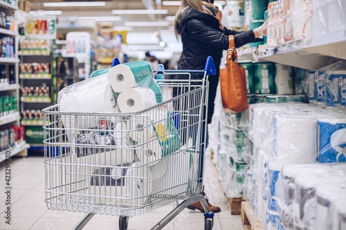 Obraz na płótnie Woman shopping at supermarket choosing toilet paper. w salonie