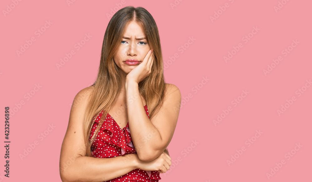 Beautiful blonde woman wearing summer dress thinking looking tired and bored with depression problems with crossed arms. Beautiful blonde woman wearing summer dress thinking looking tired and bored with depression problems with crossed arms.