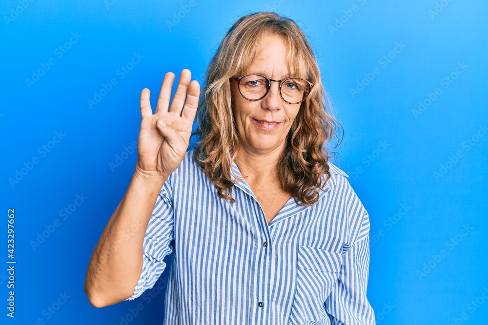 Middle age blonde woman wearing casual clothes and glasses showing and pointing up with fingers number four while smiling confident and happy. Middle age blonde woman wearing casual clothes and glasses showing and pointing up with fingers number four while smiling confident and happy.