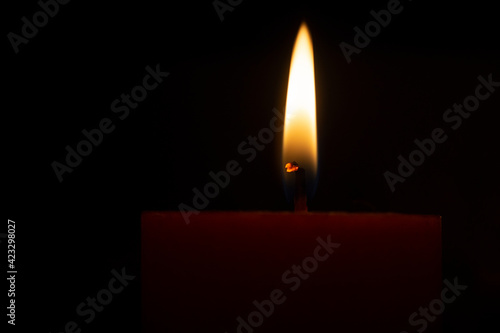 Red lighted candle on a black background