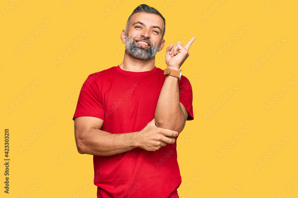 Middle age handsome man wearing casual clothes with a big smile on face, pointing with hand and finger to the side looking at the camera. Middle age handsome man wearing casual clothes with a big smile on face, pointing with hand and finger to the side looking at the camera.