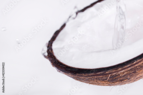 Half of a coconut with water flowing out