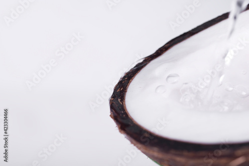 Half of a coconut with water flowing out