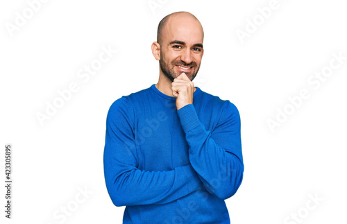 Young hispanic man wearing casual clothes looking confident at the camera with smile with crossed arms and hand raised on chin. thinking positive. © Krakenimages.com