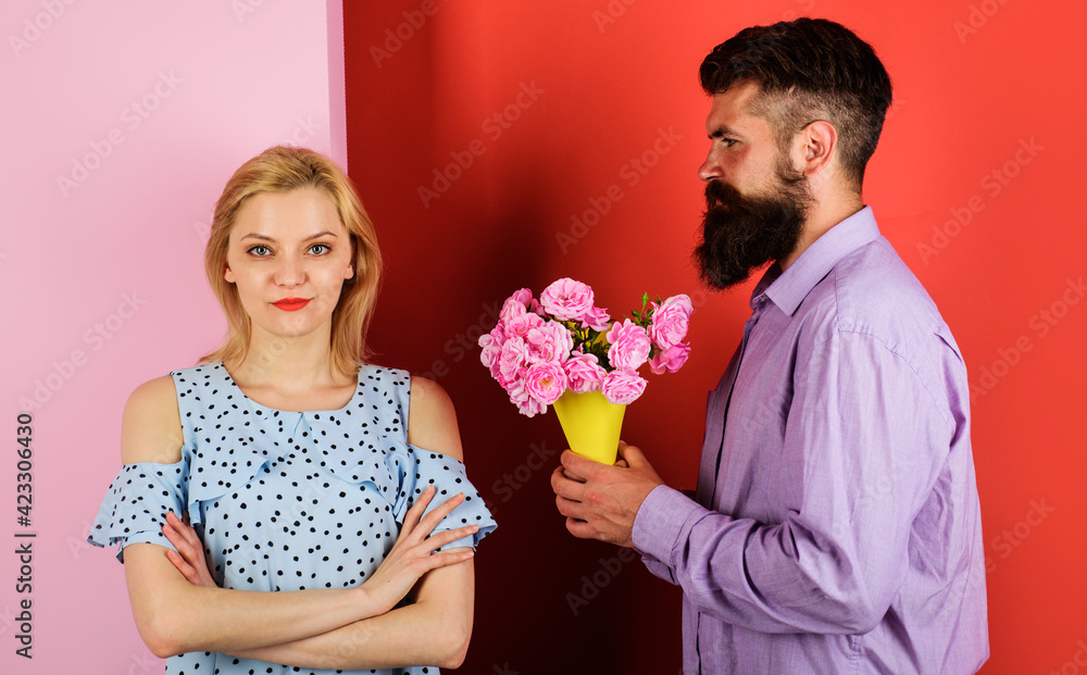 Beautiful romantic couple. Boyfriend with flowers for girlfriend. Handsome bearded man with bouquet of roses to woman. Beautiful romantic couple. Boyfriend with flowers for girlfriend. Handsome bearded man with bouquet of roses to woman.