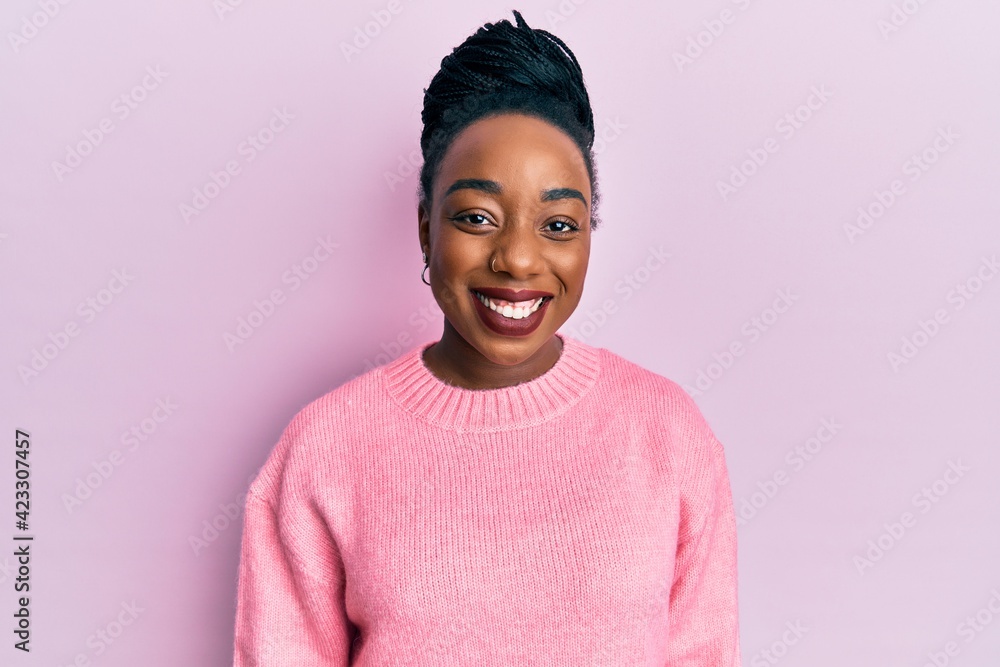 Young african american woman wearing casual winter sweater with a happy and cool smile on face. lucky person. Young african american woman wearing casual winter sweater with a happy and cool smile on face. lucky person.