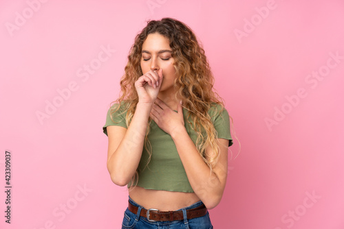Young blonde woman with curly hair isolated on pink background is suffering with cough and feeling bad