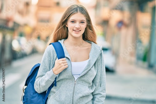 Beautiful caucasian student teenager smiling happy standing at the city.