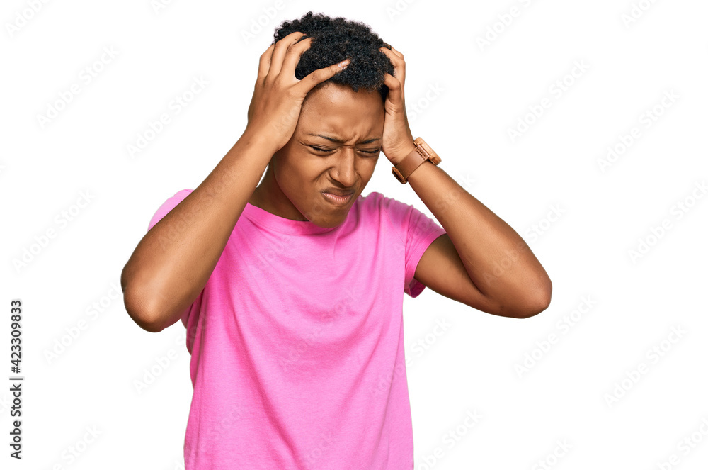 Young african american woman wearing casual clothes suffering from headache desperate and stressed because pain and migraine. hands on head. Young african american woman wearing casual clothes suffering from headache desperate and stressed because pain and migraine. hands on head.