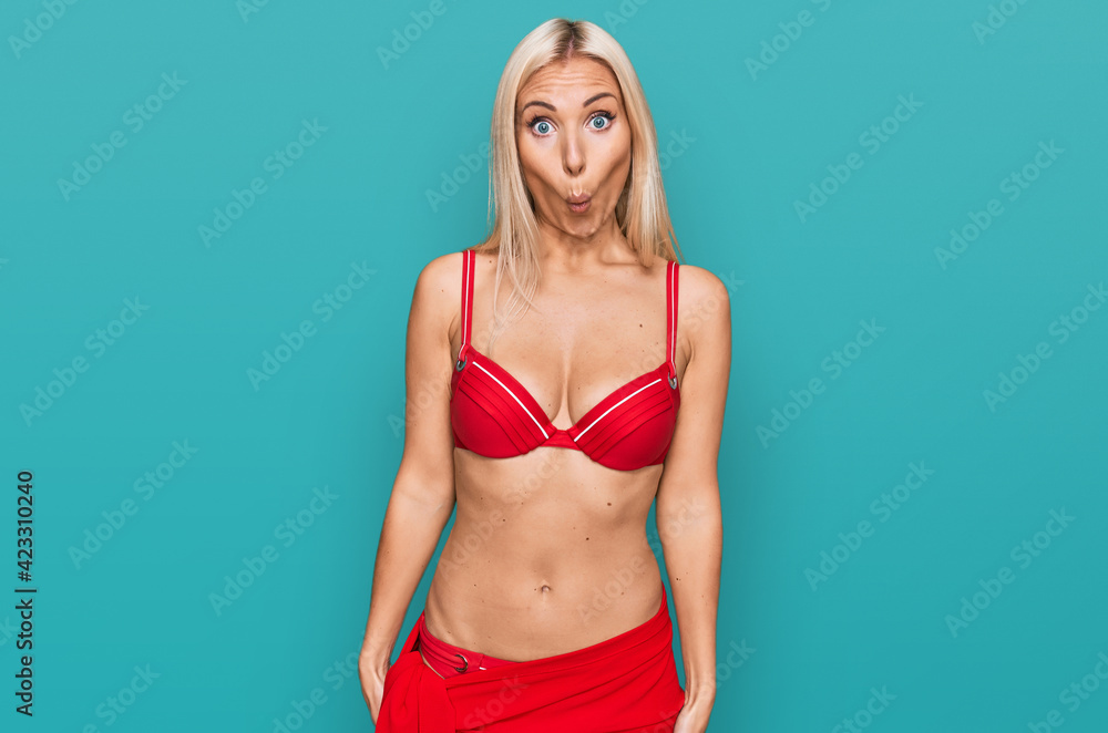 Fototapeta premium Young blonde woman wearing bikini scared and amazed with open mouth for surprise, disbelief face