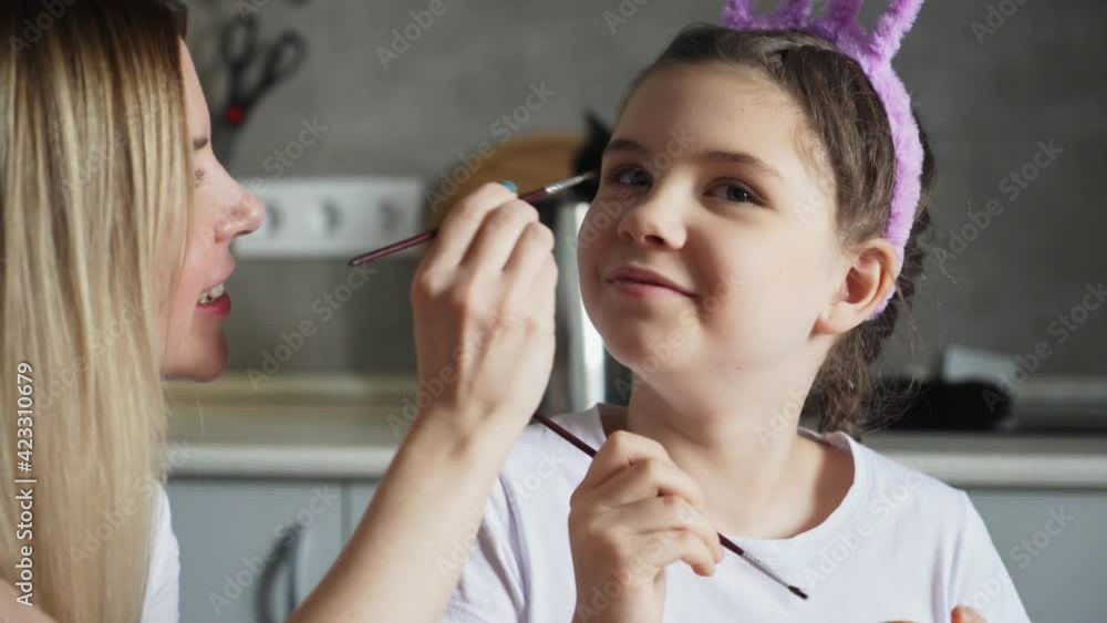 Happy easter. mother use paintbrush to play with her daughter Happy easter. mother use paintbrush to play with her daughter
