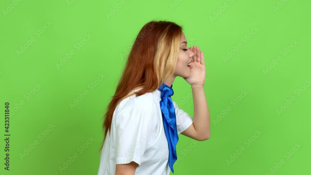 Young blonde teenager girl with stewardess uniform shouting to the lateral and announcing something over isolated background. Green screen chroma key Young blonde teenager girl with stewardess uniform shouting to the lateral and announcing something over isolated background. Green screen chroma key