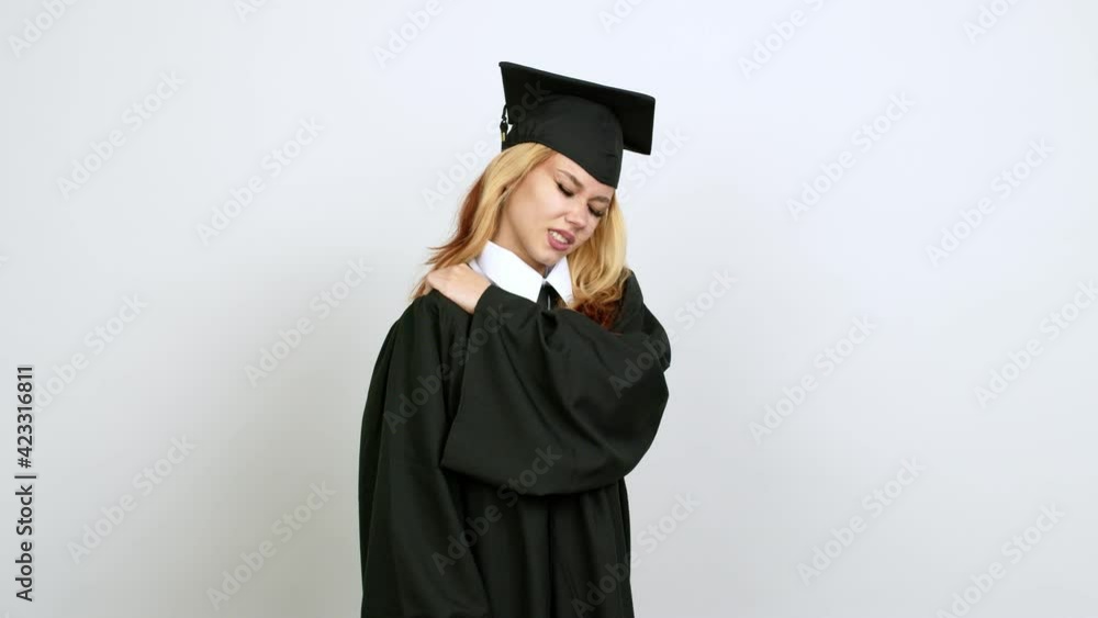 Young blonde teenager girl with graduation gown with shoulder pain over isolated background Young blonde teenager girl with graduation gown with shoulder pain over isolated background