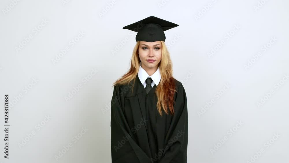 Young blonde teenager girl with graduation gown . Portratit over isolated background Young blonde teenager girl with graduation gown . Portratit over isolated background