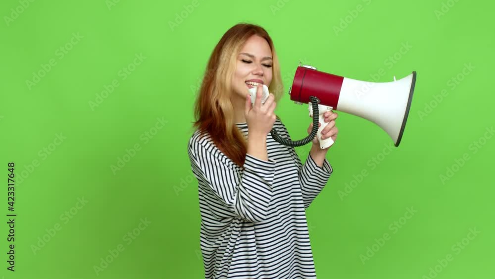 Young blonde teenager girl holding a megaphone and shouting over isolated background. Green screen chroma key Young blonde teenager girl holding a megaphone and shouting over isolated background. Green screen chroma key