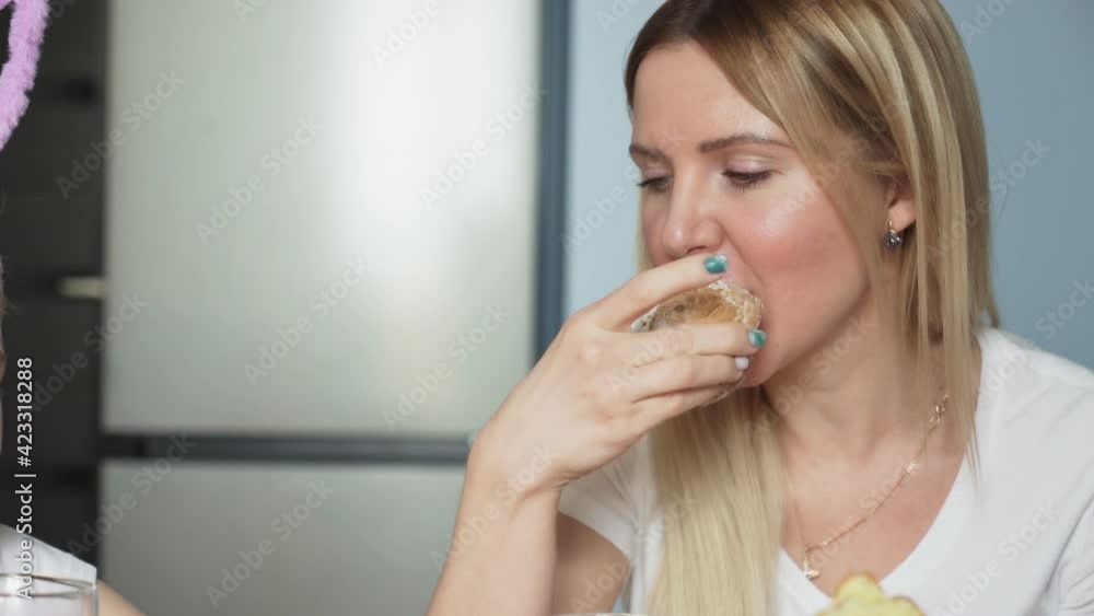 Happy Easter. Preparing the family for Easter. Mother and her little daughters drink tea and eat muffins
