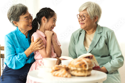 Portrait of happy asian grandmother and little asian cute girl enjoy relax in home.Young girl with their laughing grandparents smiling together.Family and togetherness