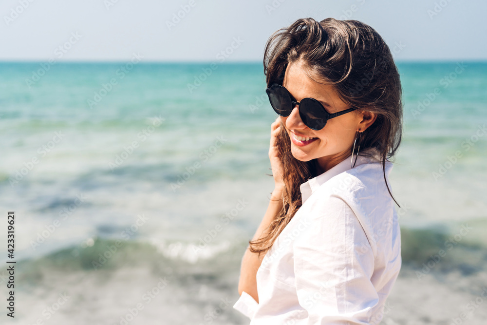 Portrait of smiling fashion woman relaxation on the tropical beach.Happy young beautiful girl enjoying and having fun on the tropical island.Summer vacations