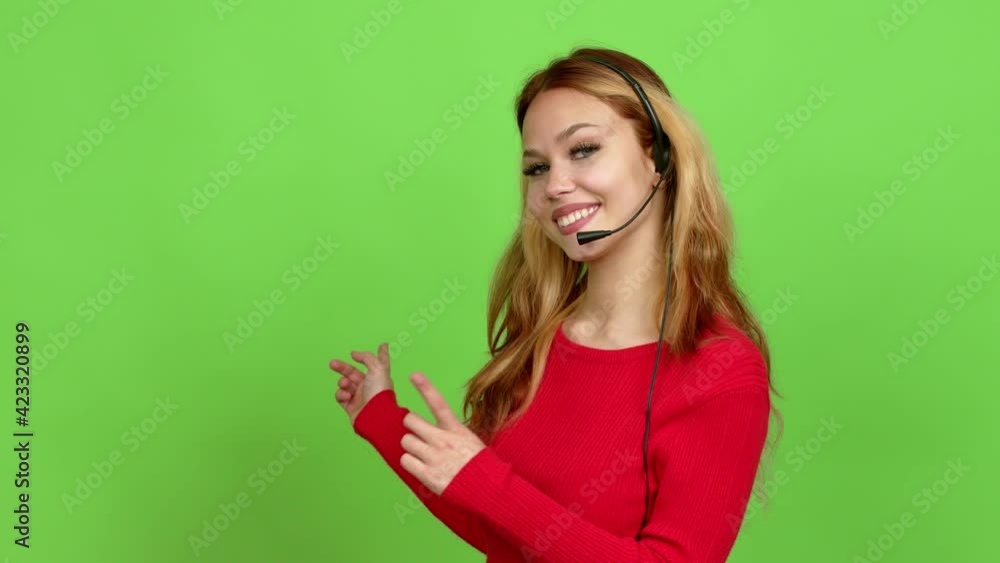 Young blonde teenager girl telemarketer pointing back and presenting a product over isolated background. Green screen chroma key Young blonde teenager girl telemarketer pointing back and presenting a product over isolated background. Green screen chroma key