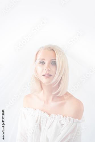 beautiful young woman bride under a veil on a white background