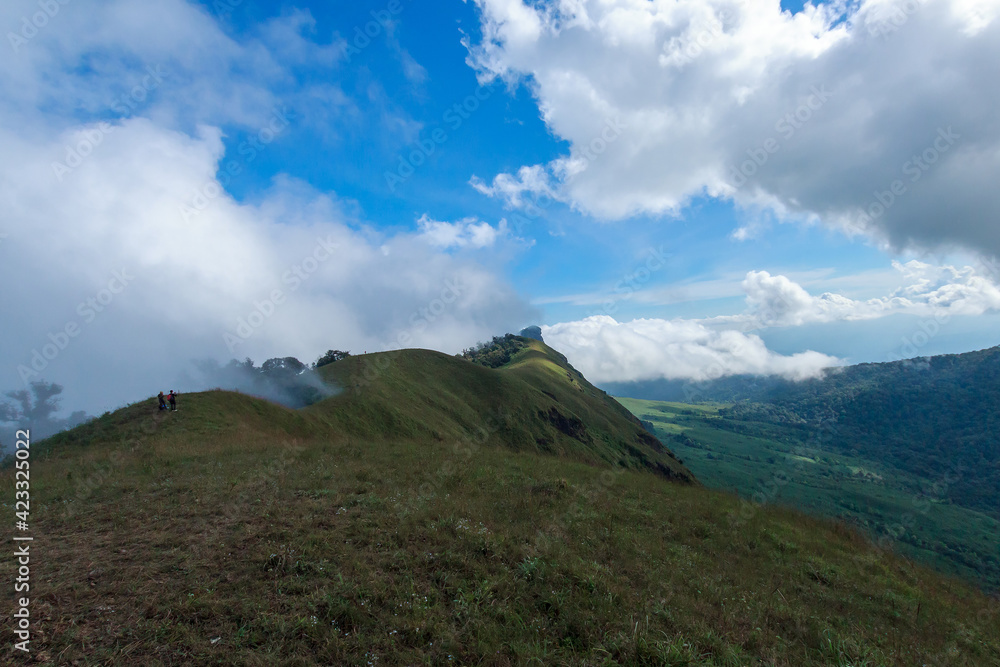 Mountain hill with grass field with sea of fog or white clouds at 
