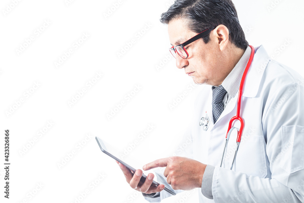 Doctor in a gown, stethoscope and tie reviewing information or diagnosis on a tablet. Medicine and technology concept Doctor in a gown, stethoscope and tie reviewing information or diagnosis on a tablet. Medicine and technology concept