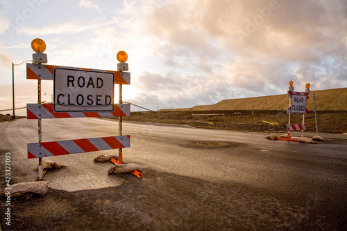Photos Closed road signs on an empty and deserted  road with bleak sky