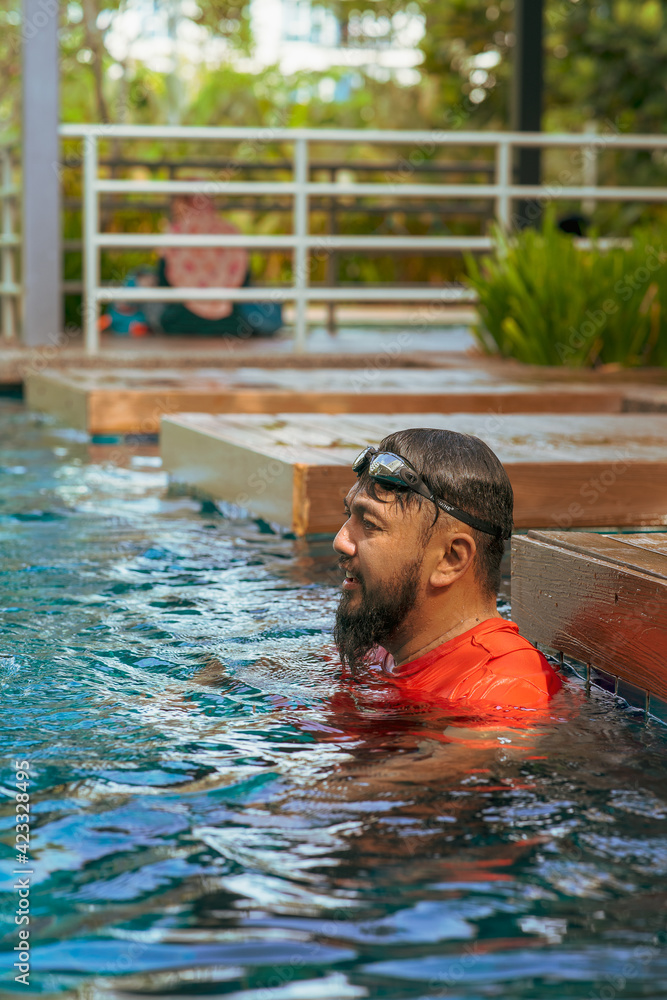 Bearded man relaxing in the swimming pool. Summer vacation