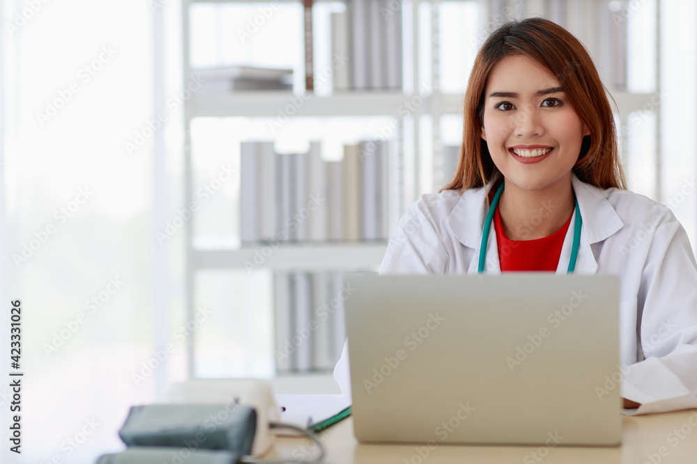 Portrait beautiful asian woman doctor wearing uniform sitting and smiling to teeth white with look at camera feel happy and confident. Stethoscope carrying on neck with copy space Portrait beautiful asian woman doctor wearing uniform sitting and smiling to teeth white with look at camera feel happy and confident. Stethoscope carrying on neck with copy space