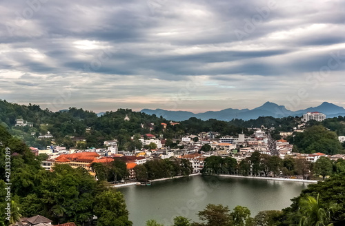 Mountain view of the city pond and buildings of Kandy city against the overcast sky in Sri Lanka © Александр Коликов