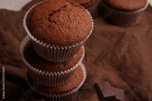 Chocolate cupcakes with cane sugar and a crispy top. Chocolate muffins on linen fabric.