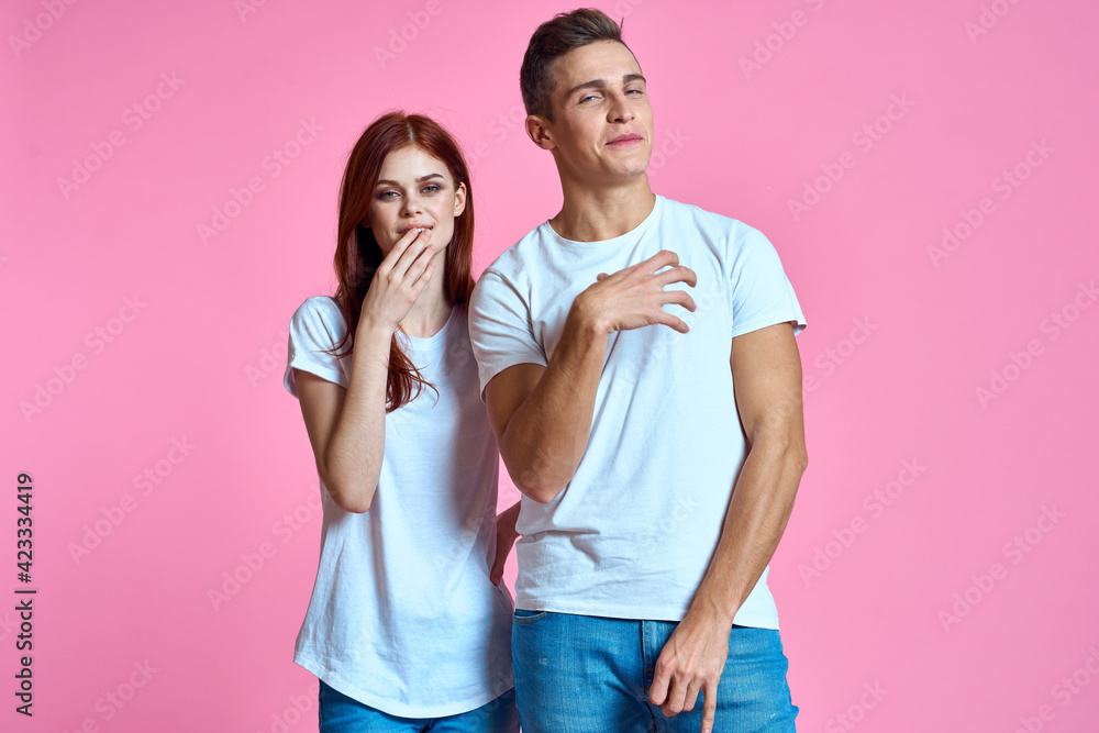 Naklejka premium Man woman in white t-shirts hugs family romance pink background
