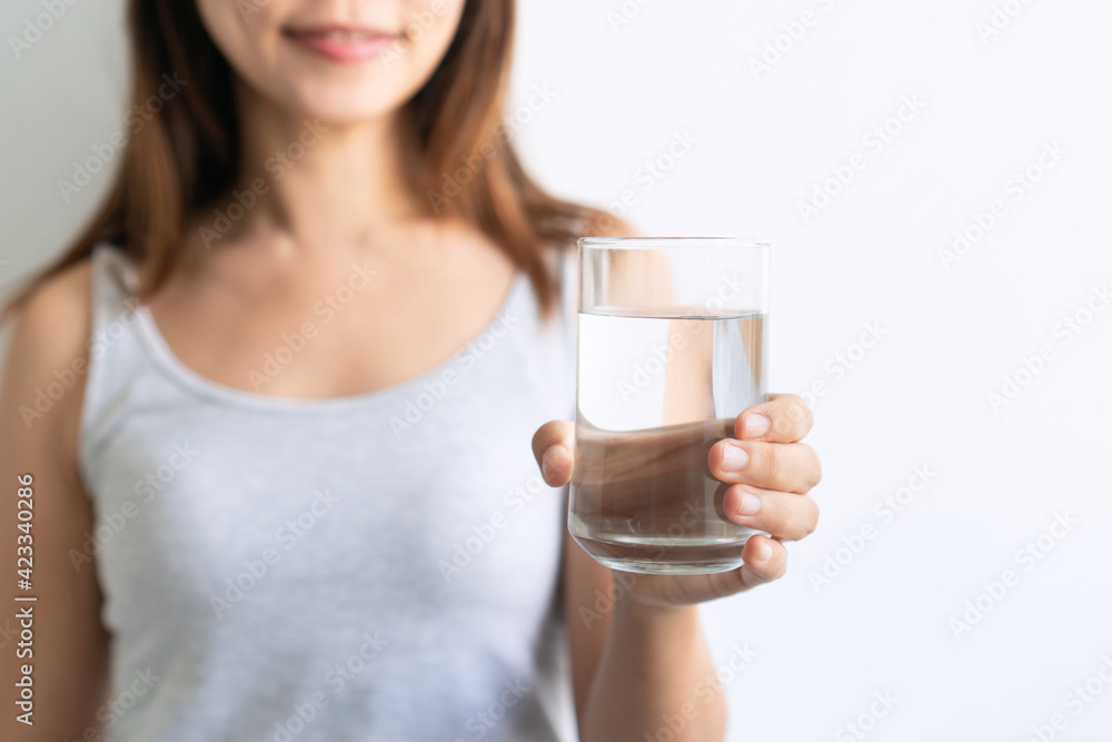 Young Asian woman holding glass of water isolated on white background. Healthy lifestyle concept. Closeup and copy space Young Asian woman holding glass of water isolated on white background. Healthy lifestyle concept. Closeup and copy space
