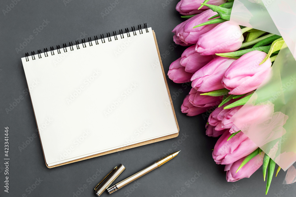 Blank notepad and bouquet of tulips on grey background. Copy space. Blank notepad and bouquet of tulips on grey background. Copy space.