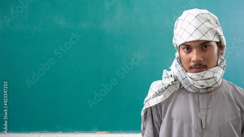 portrait of young Muslim man in traditional dress ready to pray