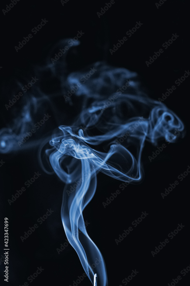 Curly blue cigarette smoke on a black background Curly blue cigarette smoke on a black background